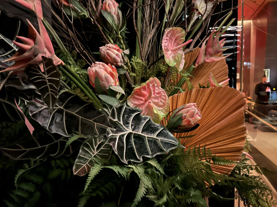 <p>A photo from the iPhone 14 showing a floral arrangement outside a restaurant in its dim foyer.</p>
