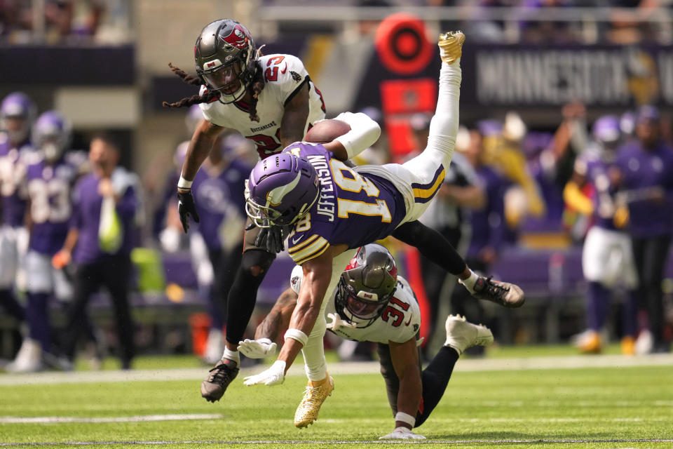 Minnesota Vikings wide receiver Justin Jefferson (18) is tackled by Tampa Bay Buccaneers safety Ryan Neal (23) and safety Antoine Winfield Jr. (31) after catching a pass during the first half of an NFL football game, Sunday, Sept. 10, 2023, in Minneapolis. (AP Photo/Abbie Parr)