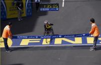 Tatyana McFadden, of the U.S. reacts as she wins the women's wheelchair division at the 118th running of the Boston Marathon in Boston, Massachusetts April 21, 2014. Holding the tape is Jun Lyu, (L) the father of Lu Lingzi, a Boston University graduate student from China that was killed in the bombings and her cousin Ziyong Meng. (REUTERS/Gretchen Ertl)