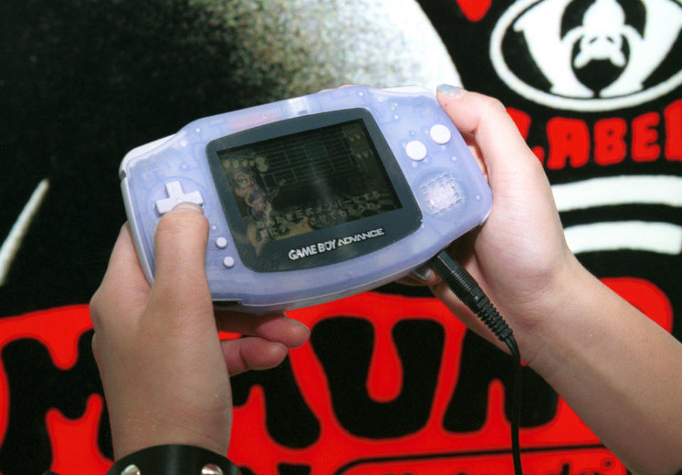 a person playing a Game Boy Advance