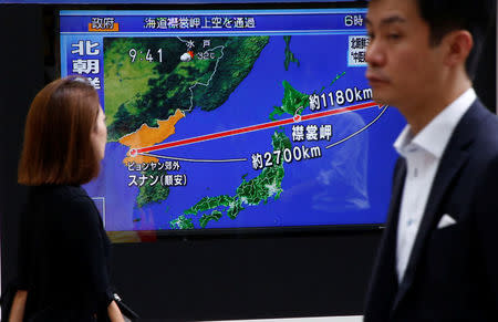 Pedestrians walk past a TV set showing news about North Korea's missile launch in Tokyo, Japan, August 29, 2017. REUTERS/Kim Kyung-Hoon