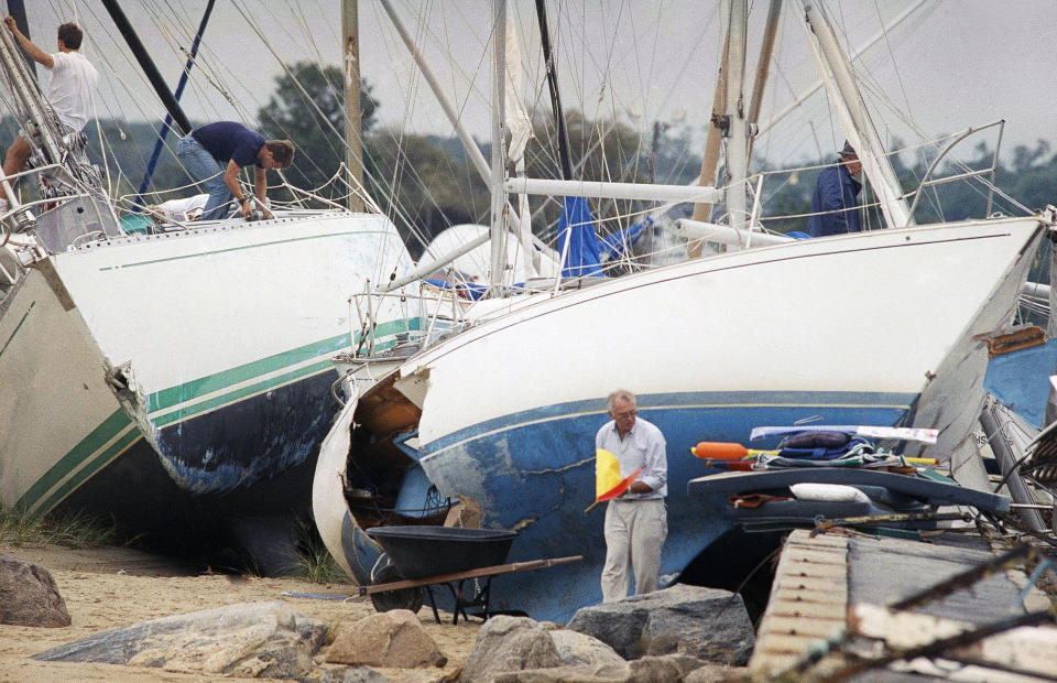 FILE - In this Aug. 20, 1991, file photo, boat owners gather their belongings along the shore in Dartmouth, Mass., after Hurricane Bob swept through southern Massachusetts. New Englanders, bracing for their first direct hit by a hurricane in 30 years, are taking precautions as Tropical Storm Henri barrels toward the southern New England coast. (AP Photo/Susan Walsh, File)