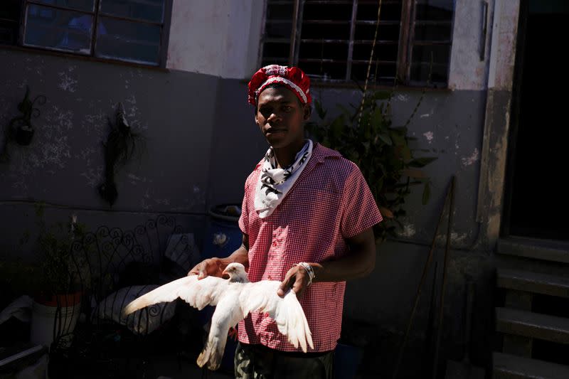 Follower of the Afro-Cuban religion Santeria holds a dove during a ceremony amid concerns about the spread of the coronavirus disease outbreak in Havana