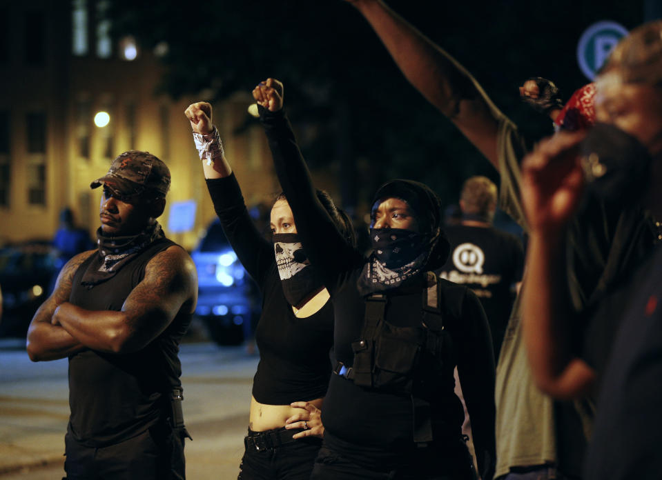 Protesters march outside the Richmond Police Department headquarters on Grace Street in Richmond, Va., Saturday, July 25, 2020. Police deployed flash-bangs and pepper spray to disperse the crowd after a city utility vehicle was set on fire. (James H Wallace/Richmond Times-Dispatch via AP)
