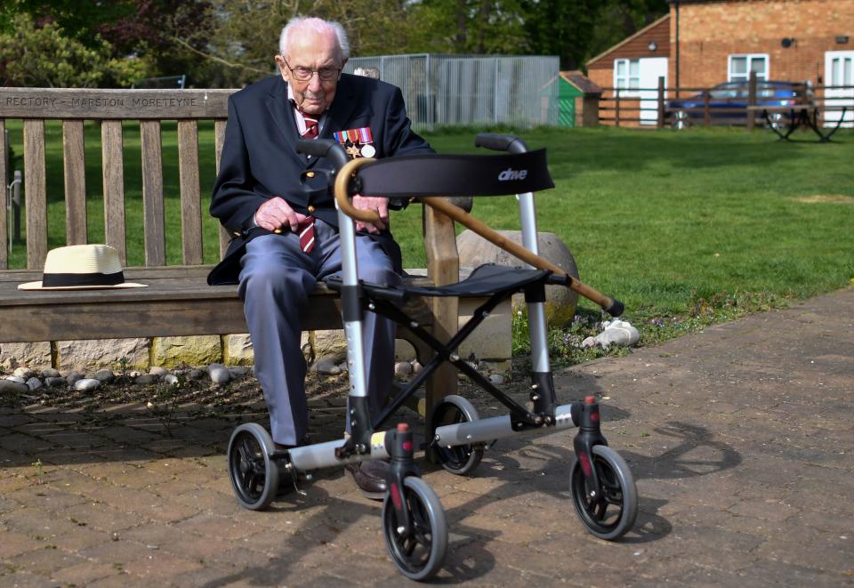 British World War II veteran Captain Tom Moore, 99, sits on a bench in the village of Marston Moretaine, 50 miles north of London, on April 16, 2020. - A 99-year-old British World War II veteran Captain Tom Moore on April 16 completed 100 laps of his garden in a fundraising challenge for healthcare staff that has "captured the heart of the nation", raising more than £13 million ($16.2 million, 14.9 million euros). "Incredible and now words fail me," Captain Moore said, after finishing the laps of his 25-metre (82-foot) garden with his walking frame. (Photo by JUSTIN TALLIS / AFP) (Photo by JUSTIN TALLIS/AFP via Getty Images)