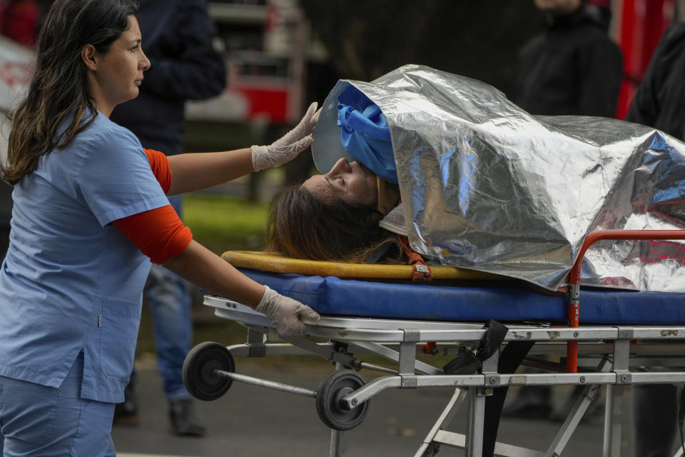 A paramedic transports an injured commuter after two trains collided in Buenos Aires, Argentina, Friday, May 10, 2024. (AP Photo/Natacha Pisarenko)