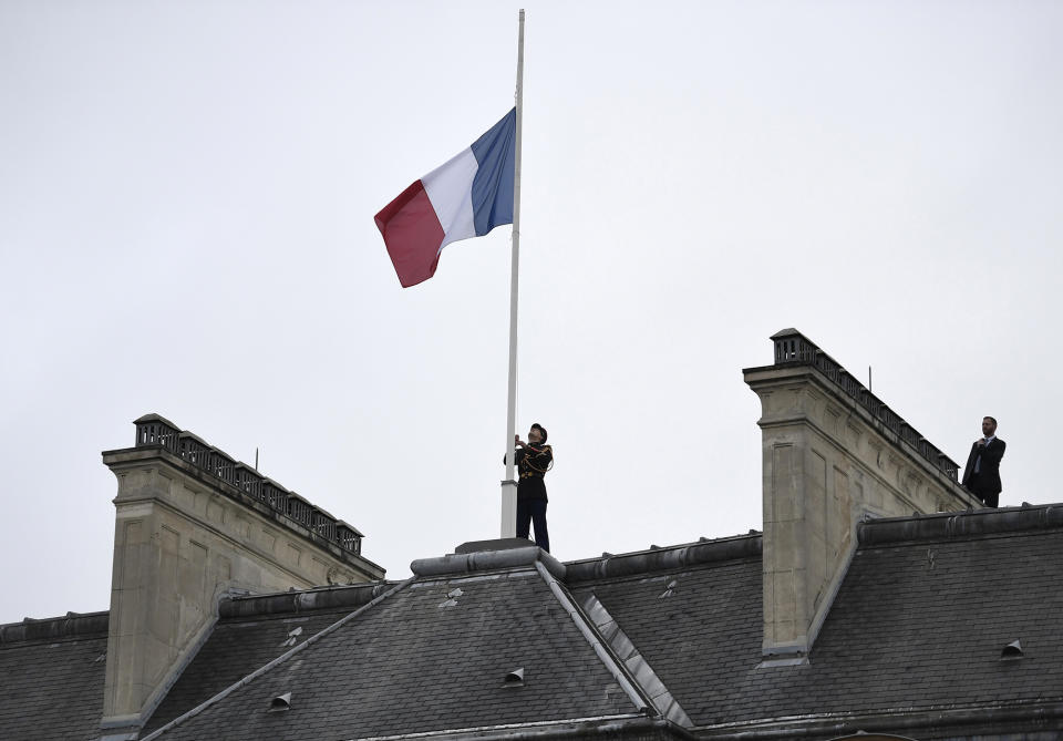 A Republican Guard flies the French flag at half mast