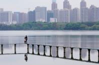 People wearing face masks hug on the East Lake in Wuhan