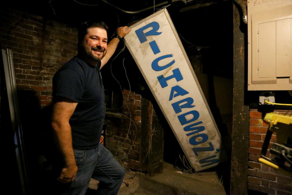 Greg Danilowski digs up the old sign from the basement of Richardson's Market in Portsmouth on Thursday, June 23, 2022.