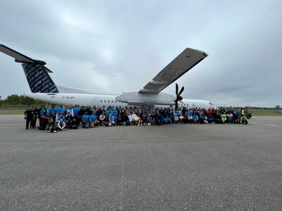 The Haul for Hope Plane Pull's 17 teams pose in front of the 67,000-lb Porter Airlines plane that each team had pulled for 100 metres. (CNW Group/Billy Bishop Toronto City Airport)