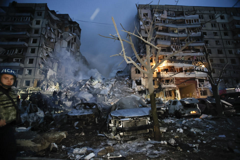 Emergency workers clear the rubble after a Russian rocket hit a multistory building leaving many people under debris in Dnipro, Ukraine, Saturday, Jan. 14, 2023. (AP Photo/Roman Chop)