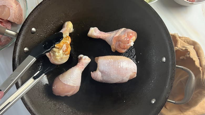 chicken pieces browning in pan