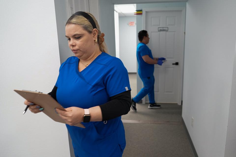 Medical assistant Liunis Peña walks between rooms at Clinica Hispana Rubymed, which provides services through telemedicine to reduce the overall cost to the patient.