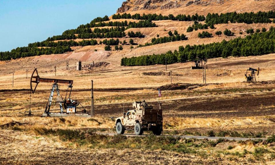 A US military armoured vehicle drives in a patrol past a an oil well in Rumaylan in Syria’s northeastern Hasakeh province.