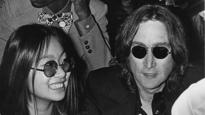 John Lennon and May Pang wearing sunglasses