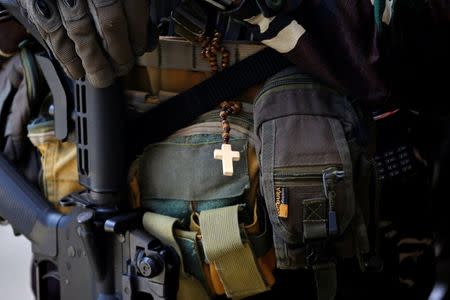 A crucifix hangs from a soldier's clothes in Marawi city, Philippines July 1, 2017. REUTERS/Jorge Silva