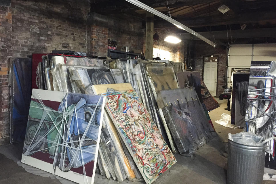 Paintings by Francis Hines sit wrapped in plastic in a barn Sept. 27, 2017, in Watertown, Conn. After fading into obscurity, Hines, who died in 2016, is again gaining attention after hundreds of his paintings were rescued by a car mechanic from a dumpster in Connecticut. An exhibit of that art will open May 5, 2022, at the Hollis Taggart galley in Southport, which is known for showing the works of lost or forgotten artists. (Jared Whipple via AP)