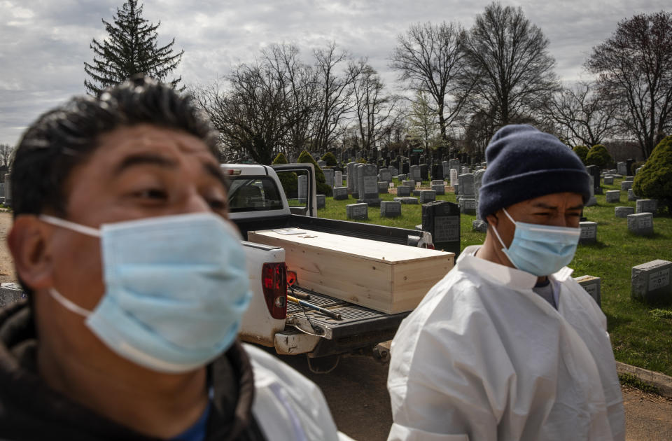 The casket of someone presumed to have died from coronavirus waits to be buried without any family present at Hebrew Free Burial Association's Mount Richmond Cemetery in the Staten Island borough of New York, Tuesday, April 7, 2020. The group buries Jews who die with little or nothing. A century ago, it buried garment workers killed in the Triangle Shirtwaist fire and those who fell to the Spanish flu. More recently, it was Holocaust survivors who fled Europe. And now, those dying of the coronavirus. (AP Photo/David Goldman)