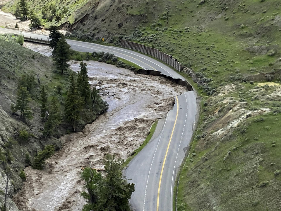 This aerial photo provided by the National Park Service shows a washed out road at North Entrance Road, of Yellowstone National Park in Gardiner, Mont., on June 13, 2022. Flooding caused by heavy rains over the weekend caused road and bridge damage in Yellowstone National Park, leading park officials to close all the entrances through at least Wednesday. Gardiner, a town just north of the park, was isolated, with water covering the road north of the town and a mudslide blocking the road to the south. (Doug Kraus/National Park Service via AP)