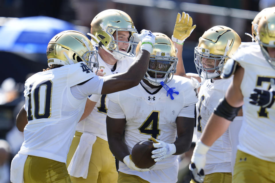 Notre Dame running back Jeremiyah Love (4) is congratulated by teammates after scoring a touchdown against Purdue during the first half of an NCAA college football game in West Lafayette, Ind., Saturday, Sept. 14, 2024. (AP Photo/Michael Conroy)