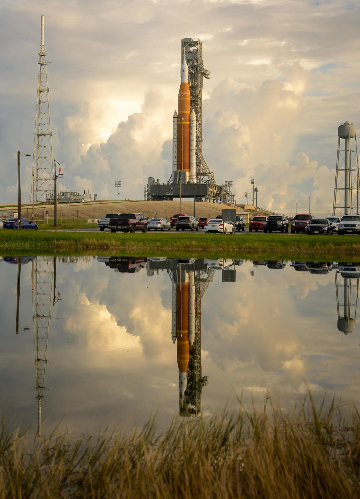 Still water in a pond near pad 39B captures a reflected image of the Space Launch System moon rocket Friday before afternoon storms built up along Florida's Space Coast.  / Credit: NASA/Bill Ingalls