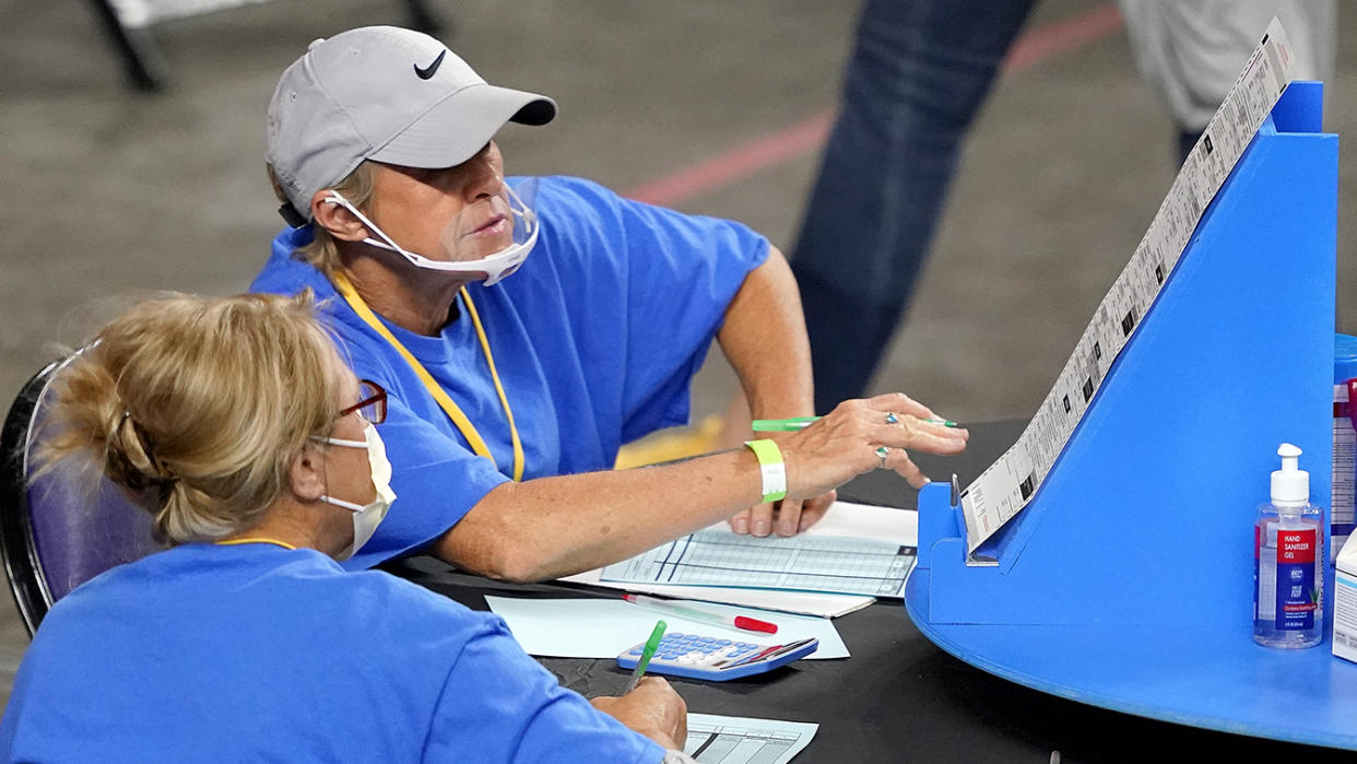 Maricopa County ballots cast in the 2020 general election are examined and recounted by contractors working for Florida-based company, Cyber Ninjas, Thursday, May 6, 2021 at Veterans Memorial Coliseum in Phoenix. (Matt York/Pool via AP)