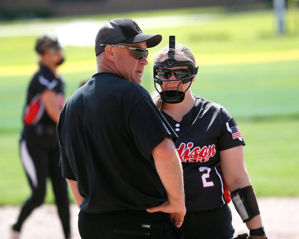 Addison co-head coach Justin Patterson talks with Isabelle Patterson in the pitcher's circle during a game against Lenawee Christian.