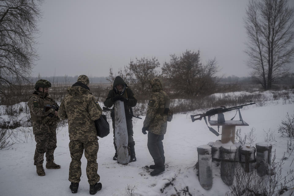Ukrainian Territorial Defence Force members chat as one of them holds remains of a rocket that was allegedly shot down after a Russian attack in Kyiv, Ukraine, Friday, Dec. 16, 2022. Ukrainian authorities reported explosions in at least three cities Friday, saying Russia has launched a major missile attack on energy facilities and infrastructure. Kyiv Mayor Vitali Klitschko reported explosions in at least four districts, urging residents to go to shelters. (AP Photo/Felipe Dana)