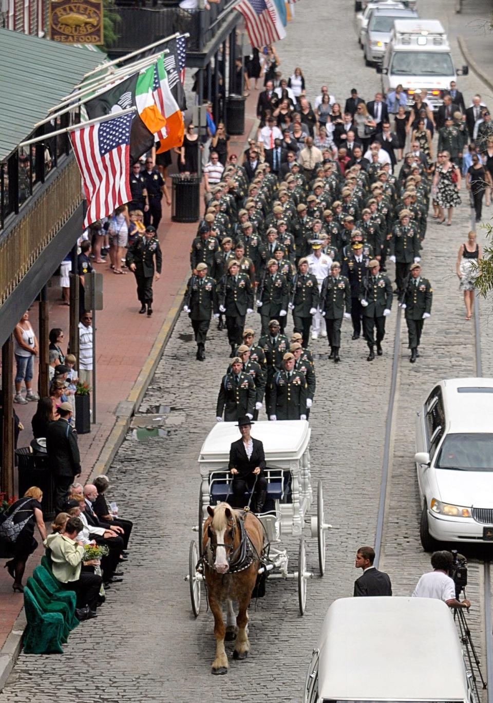 The horse drawn casket carrying the remains of Sgt. Jonathan Peney leads the funeral procession as it heads east on River Street to Kevin Barry's. June 11, 2010