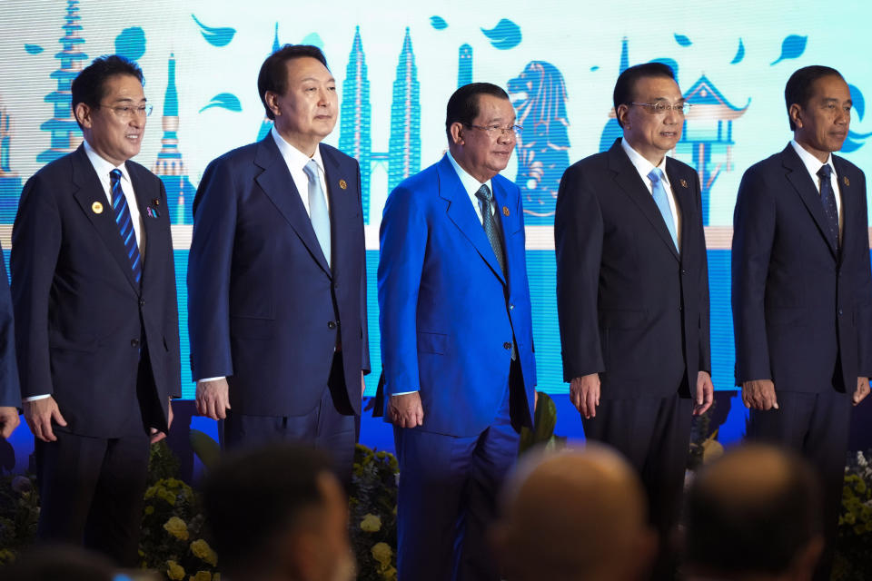 FILE - Left to right; Japan's Prime Minister Fumio Kishida, South Korea's President Yoon Suk Yeol, Cambodia Prime Minister Hun Sen, Chinese's Premier Li Keqiang and Indonesia's President Joko Widodo stand for group photo of the ASEAN Plus Three Summit (Association of Southeast Asian Nations) in Phnom Penh, Cambodia, Saturday, Nov. 12, 2022. Hun Sen said Tuesday, Nov. 15, 2022, he has tested positive for COVID-19 at the Group of 20 meetings in Bali, just days after hosting many world leaders, including President Joe Biden, for a summit in Phnom Penh. (AP Photo/Vincent Thian, File)