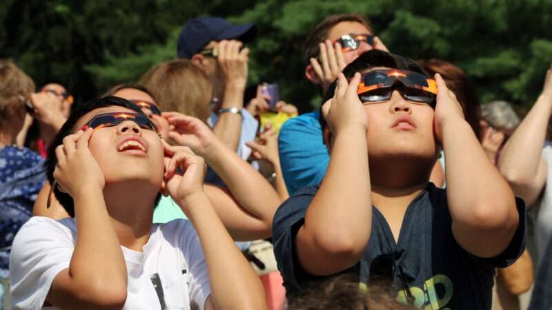 Kids with glasses stare at solar eclipse