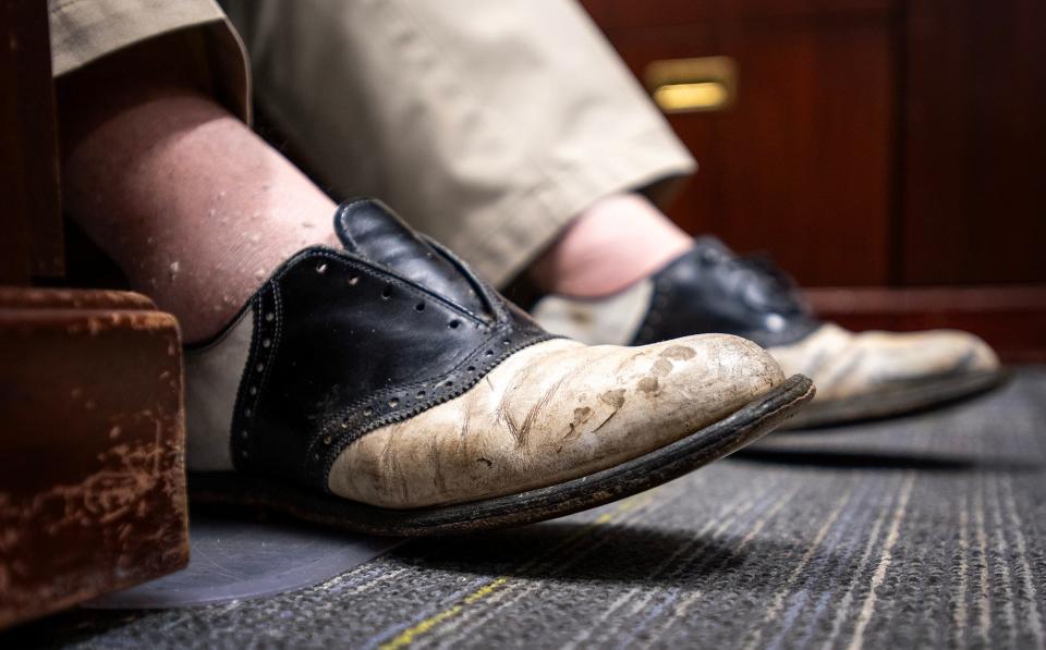 Dr. Robert Babineau Jr. wears a worn-out pair of his favorite style of saddle shoes in his Fitchburg office.