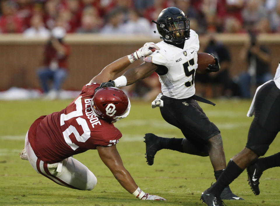 Army running back Kell Walker (5) avoids a tackle by Oklahoma defensive end Amani Bledsoe (72) in the first half of an NCAA college football game in Norman, Okla., Saturday, Sept. 22, 2018. (AP Photo/Sue Ogrocki)