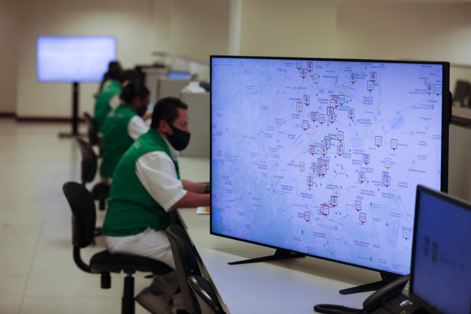 A map, with most hospitals marked in red to show they are already at capacity, displays information about which hospitals in Mexico's hard-hit capital still have space to accept COVID-19 patients, as workers from the Ministry of Health make round-the-clock updates to the database in the C5 emergency operations center in Mexico City, Friday, May 15, 2020. The C5 operations center, normally empty until the country needs to respond to large disasters such as earthquakes, is now being used to manage the city's response to the coronavirus pandemic, with distanced workers tracking data on hospital bed availability, tallying statistics on the sick and the dead, and directing citizens where to go for care. (AP Photo/Rebecca Blackwell)