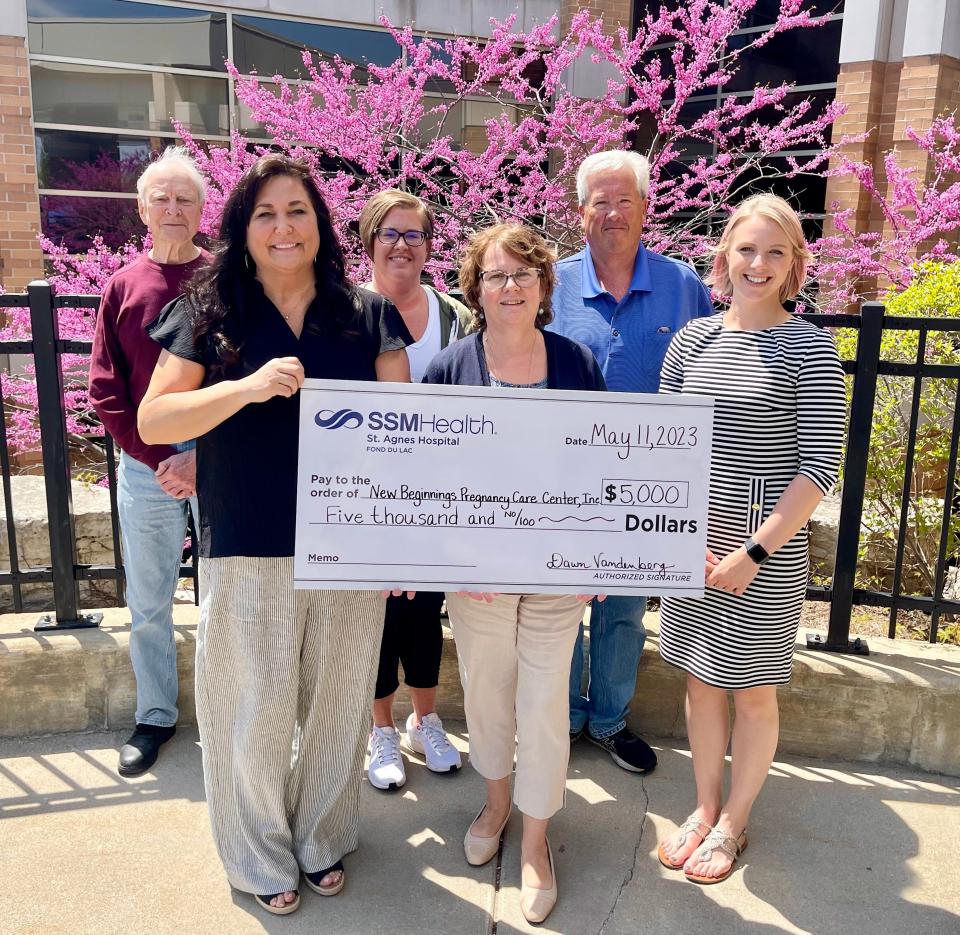 Dawn Vandenberg, center front, SSM Health Mission Integration regional director, presents a $5,000 donation to the New Beginnings Pregnancy Care Center to, first row, from left, Kelly Rust, executive director, Ashley Deiler, president; second row, from left, Don Caven, secretary, Kristi Anderson, vice president, and John Lowney, board member.