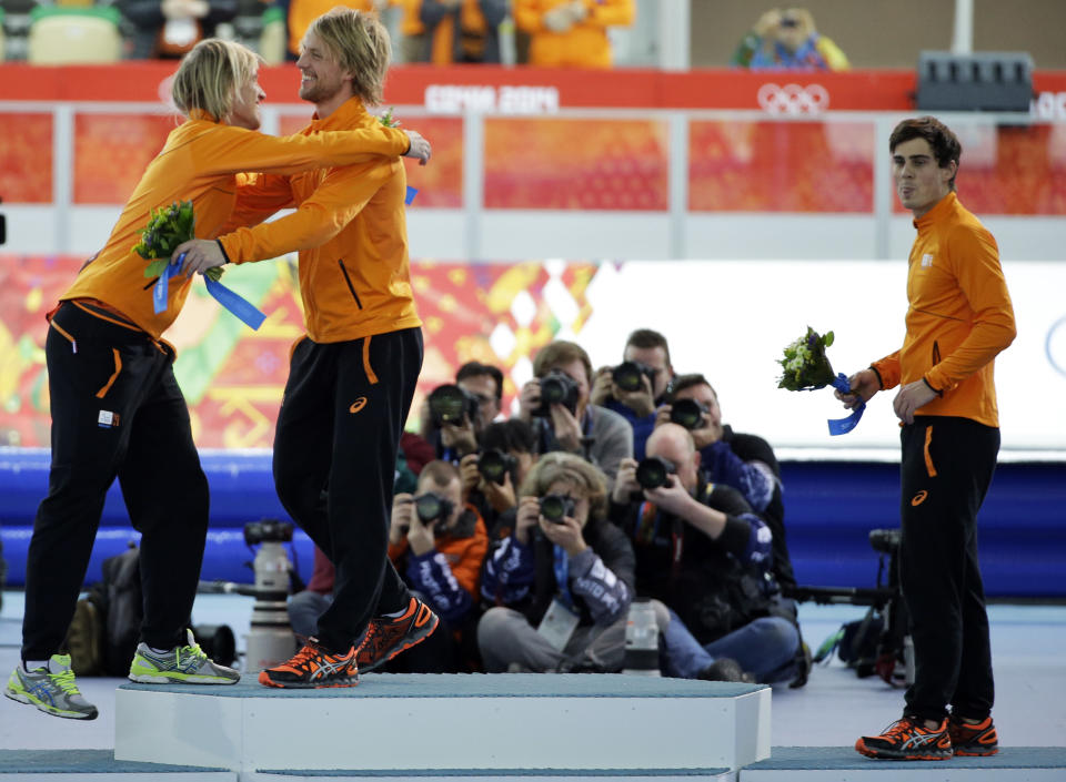 Twin brothers from the Netherlands, gold medallist Michel Mulder, second right, and bronze medallist Ronald, left, hug as silver medallist Jan Smeekens of the Netherlands, who lost the gold medal by 12 thousandth of a second, stands beside, in the men's 500-meter speedskating race at the Adler Arena Skating Center at the 2014 Winter Olympics, Monday, Feb. 10, 2014, in Sochi, Russia. (AP Photo/David J. Phillip)