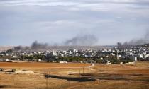 Smoke rises from the Syrian town of Kobani, seen from near the Mursitpinar crossing on the Turkish-Syrian border in the southeastern town of Suruc in Sanliurfa province, October 20, 2014. REUTERS/Kai Pfaffenbach