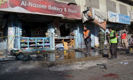 Rescue workers and crime scene investigators inspect the site of a suicide bomb attack close to a polio eradication centre in Quetta, Pakistan, January 13, 2016. REUTERS/Stringer