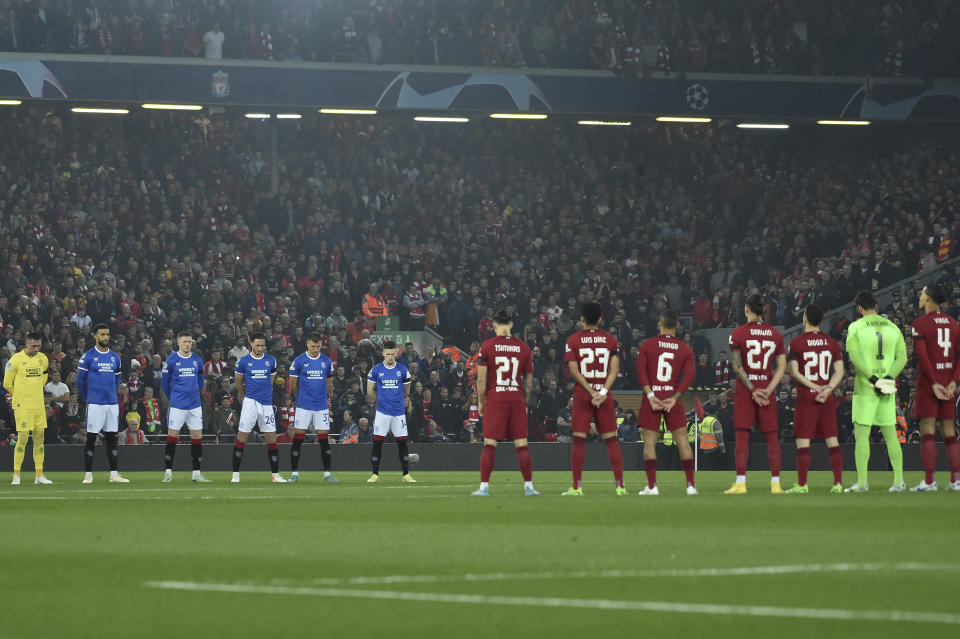 Players observe a minute of silence, in the memory of the fatal victims of a stampede during a soccer match in Indonesia, before the Champions League Group A soccer match between Liverpool and Rangers at Anfield stadium in Liverpool, England, Tuesday Oct. 4, 2022. (AP Photo/Rui Vieira)