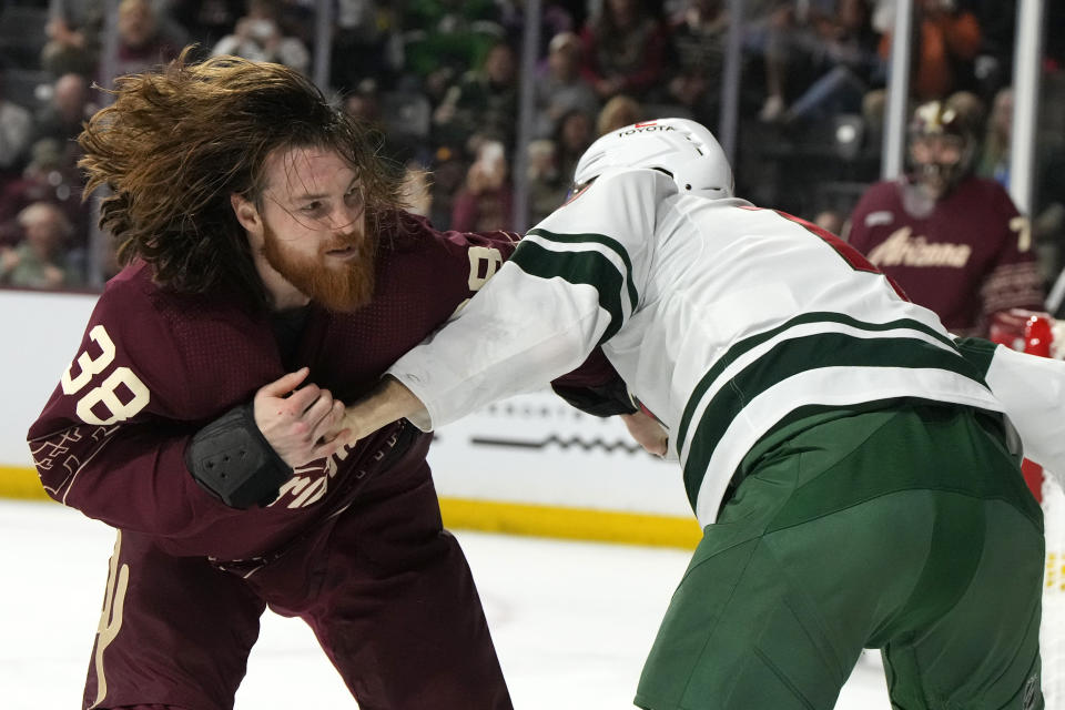 Arizona Coyotes center Liam O'Brien (38) battles with Minnesota Wild left wing Marcus Foligno in the first period during an NHL hockey game, Sunday, March 12, 2023, in Tempe, Ariz. (AP Photo/Rick Scuteri)