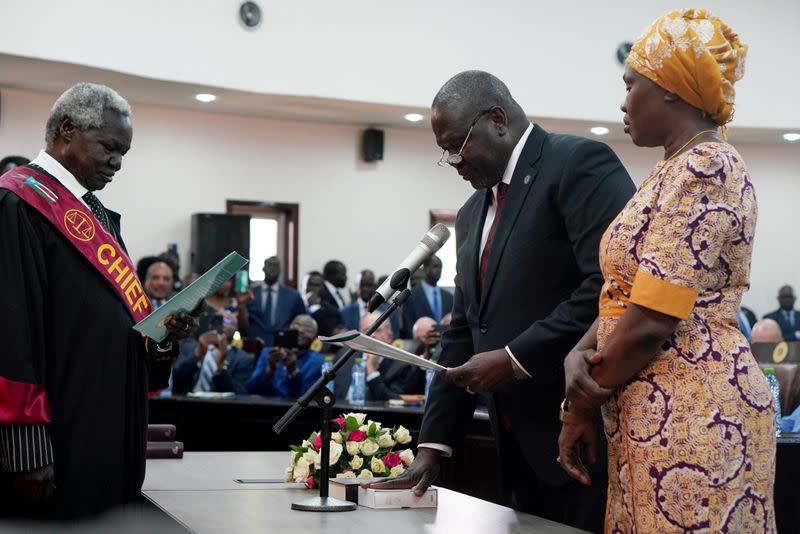 South Sudan's First Vice President Riek Machar stands with his wife Angelina Teny as he takes the oath of office in front of Chief of Justice Chan Reech Madut, at the State House in Juba