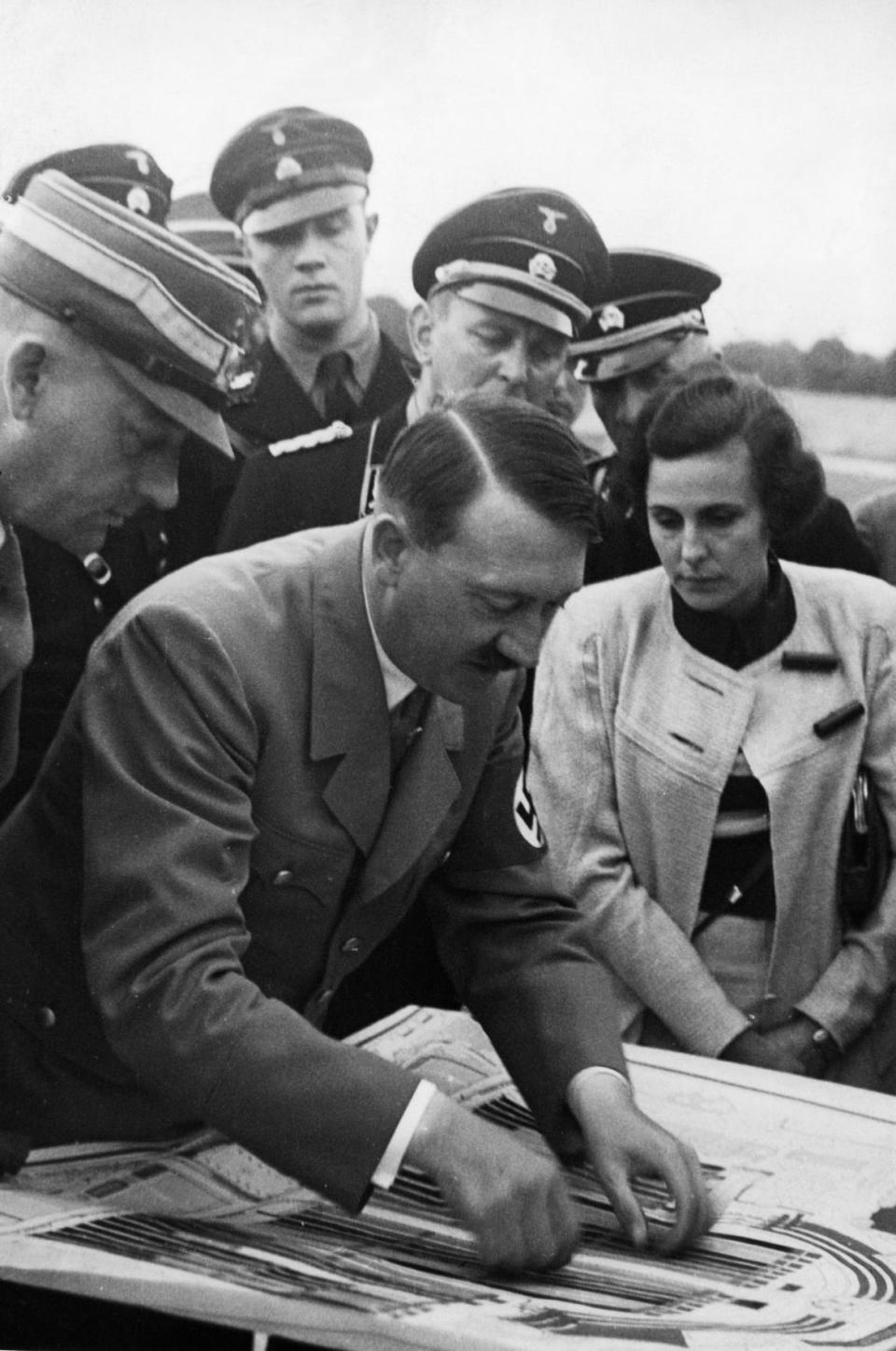 <div class="inline-image__caption"><p>Adolf Hitler checking plans for the forthcoming parades on the terrain of the Nuremberg rally and Leni Riefenstahl, at right, who was commissioned to shoot the official film about the rally, on Aug 20, 1934.</p></div> <div class="inline-image__credit">Heinrich Hoffmann/ullstein bild via Getty</div>