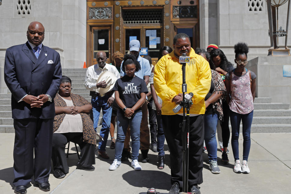 FILE - In this Wednesday, June 10, 2020 file photo, Pastor Linus Mays leads a prayer at the start of a news conference with family of Tommie McGlothen, Jr., outside the Caddo Parish Courthouse with attorney James Carter, left, in Shreveport, La. Relatives of a Black man who died after an altercation with police have filed a federal lawsuit against a northwest Louisiana city and four of its officers. The suit filed Tuesday, March 16, 2021 stems from the death last April of McGlothen Jr. in Shreveport. The four Shreveport officers named in the suit face state criminal charges and have pleaded not guilty. (AP Photo/Gerald Herbert, File)