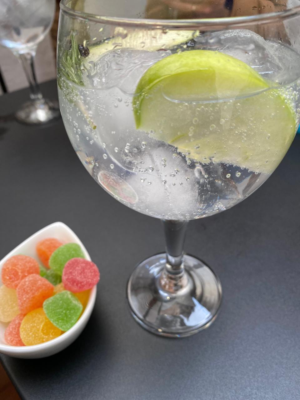 A gin and tonic and bowl of gummies