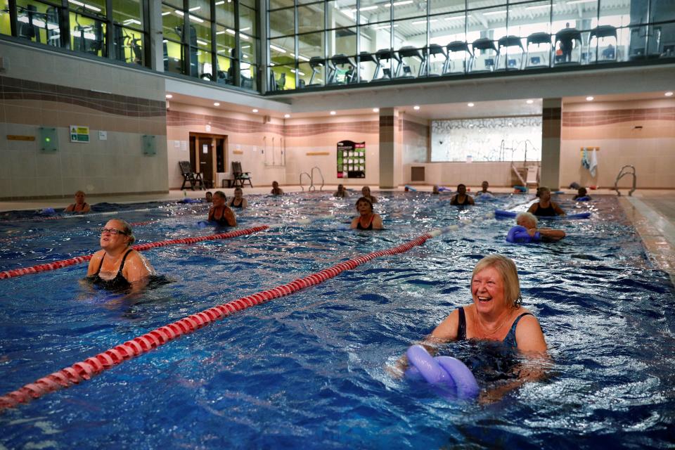 Ladies exercise during an aqua fit class in the swimming pool at Nuffield Health Sunbury Fitness and Wellbeing Gym in Sunbury-on-Thames, west of London on July 25, 2020 as novel coronavirus lockdown restrictions are eased to allow gyms, leisure centres and indoor swimming pools in England to reopen. - England's gyms, leisure centres and indoor swimming pools were allowed to open their doors on July 25 for the first time since the March shutdown was introduced to combat the novel coronavirus COVID-19 pandemic. (Photo by ADRIAN DENNIS / AFP) (Photo by ADRIAN DENNIS/AFP via Getty Images)