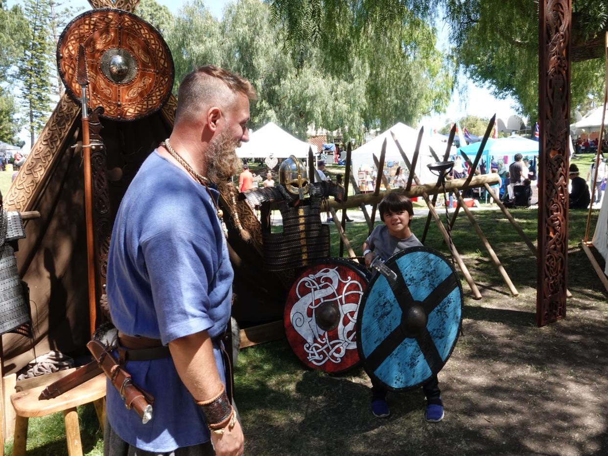 Carlos Galin, left, teaches Viking swordplay to Santiago Simonton, 6, of Newbury Park, at the 2019 Scandinavian Festival at California Lutheran University. The event returns Saturday and Sunday for its 50th anniversary.
