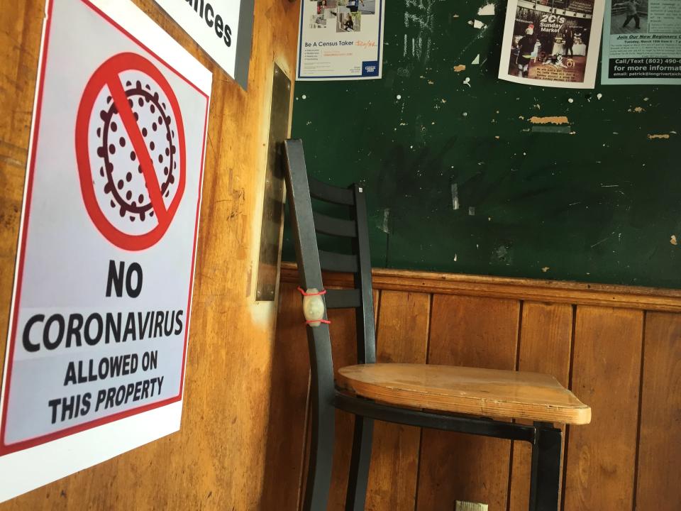 Signs and posters that were up as the COVID-19 pandemic arrived in March 2020 remain on display July 20, 2021 at Esox bar in Burlington.