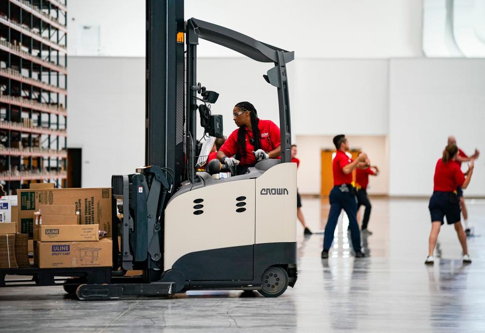 Employees begin moving pallets at the Uline warehouse in Naples on Tuesday, April 18, 2023.