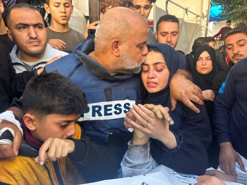 El periodista de Al Jazeera, Wael Al-Dahdouh, abraza a su hija y a su hijo mientras asisten al funeral de su hijo, el periodista palestino Hamza Al-Dahdouh, después de que Hamza muriera en un ataque israelí, en Rafah, en el sur de la Franja de Gaza