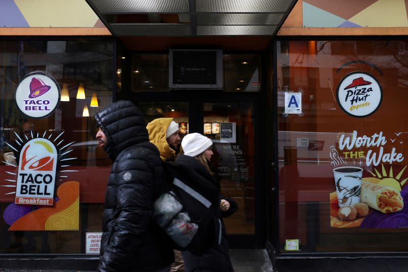 FILE PHOTO: People walk by a Taco Bell and Pizza Hut, subsidiaries of Yum! Brands, Inc. in Manhattan, New York City